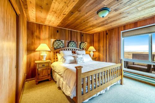 a bedroom with a bed with a wooden ceiling and a window at Captain's Quarters in Seaside