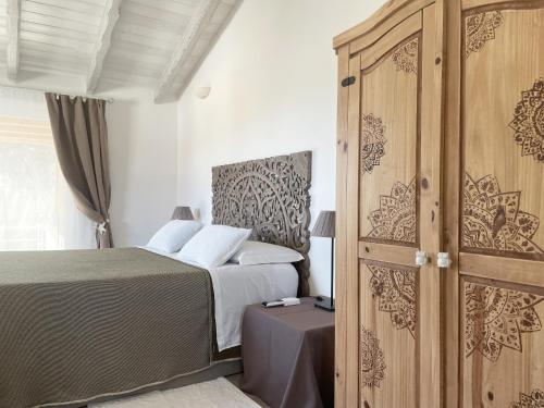 Schlafzimmer mit einem Bett und einem Holzschrank in der Unterkunft Sea Love in Olbia