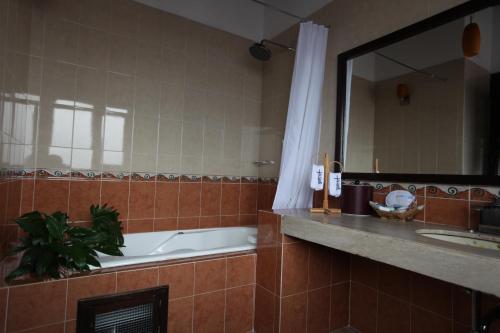 a bathroom with a tub and a sink and a mirror at La Capilla Hotel Boutique in Valle de Bravo