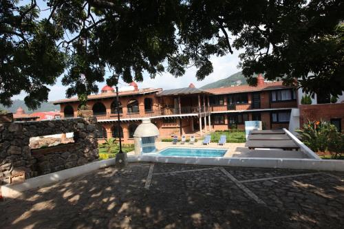 a large building with a swimming pool in front of it at La Capilla Hotel Boutique in Valle de Bravo