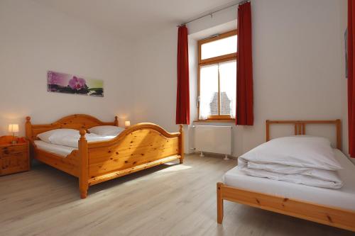 een slaapkamer met 2 bedden en een raam bij Rössle Apart FeWo in Friedenweiler