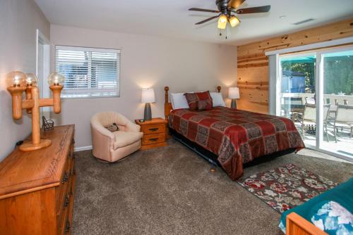 een slaapkamer met een bed, een stoel en een raam bij Kitkats Hideaway-1874 by Big Bear Vacations in Big Bear Lake
