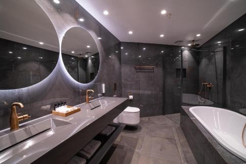 a bathroom with a tub and a toilet and a sink at Sorrisniva Arctic Wilderness Lodge in Alta