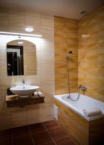 a bathroom with a sink and a bath tub at The Nest Boutique in Baia Mare