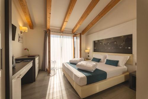 a bedroom with a bed and a large window at Hi Hotels Trento - Wellness & Spa Adults Only in Trento