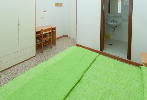 Habitación con alfombra verde en el baño. en Hotel Amalfi & Dépendance, en Lignano Sabbiadoro
