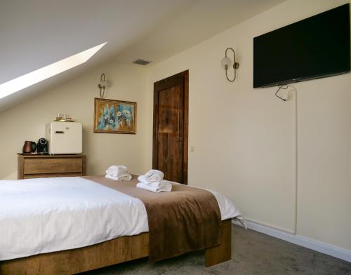 a bedroom with a bed and a flat screen tv at The Nest Boutique in Baia Mare