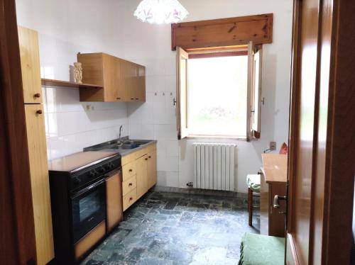 una pequeña cocina con fregadero y ventana en Dimora di nonna Nina, en Galatone