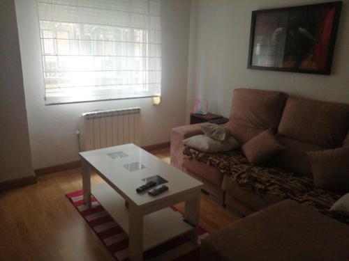 a living room with a couch and a coffee table at Luminoso, tranquilo in Aranjuez