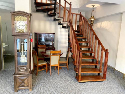 a staircase with a table and a clock in a room at Rogas Home in Tbilisi City