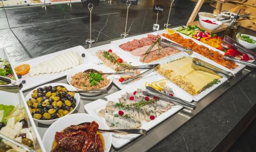 a table topped with lots of different types of food at Loop Hotel Vilnius in Vilnius