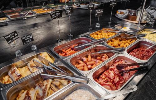 a buffet with many trays of different types of food at Loop Hotel Vilnius in Vilnius