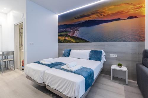 1 dormitorio con 1 cama con una pintura en la pared en Santa Marina Apartamentuak Zarautz, en Zarautz