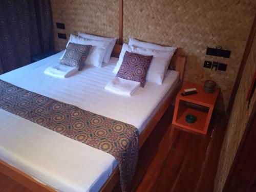 two twin beds in a room with a night stand at At Home in Puerto Princesa City