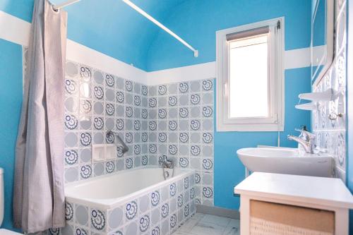 uma casa de banho azul com uma banheira e um lavatório em Le Roulis em Saint-Cast-le-Guildo