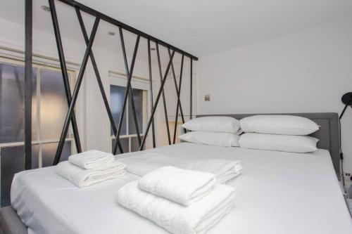 two beds with white towels on top of them at Stylish Apartment in Central London - Farringdon in London