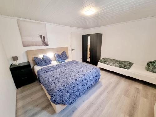 1 dormitorio con cama con sábanas azules y ventana en RELAX Wohnung Groß Rohrheim, en Groß-Rohrheim