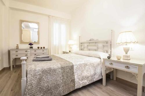 um quarto branco com uma cama e uma secretária em Casa Marina Malaga em Málaga