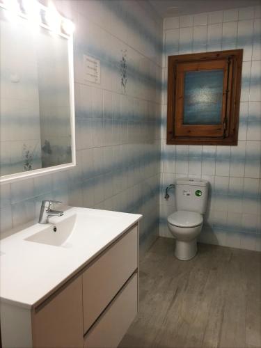 a bathroom with a white sink and a toilet at Apartamentos Arco Iris in Punta Grossa