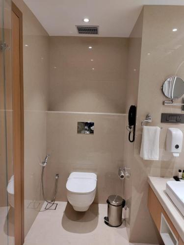 a bathroom with a toilet and a shower and a sink at Damson Plum in Lucknow