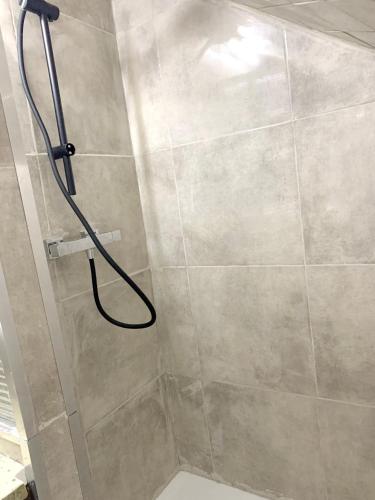 une douche avec un tuyau dans une salle de bain dans l'établissement Maison spacieuse à Saint-Brice-sous-Forêt avec jardin 90 m², à Saint-Brice-sous-Forêt