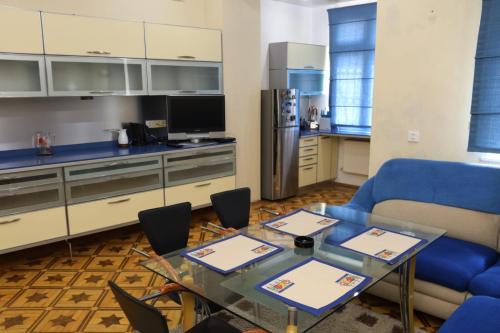 a kitchen with a glass table and a blue couch at Azneft Royal Suite Apartment Sea View in Baku