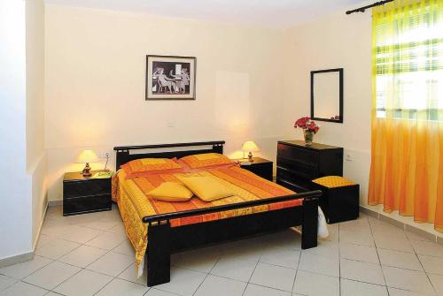 PrínosにあるPrinosのベッドルーム1室(オレンジのシーツと黄色の枕が備わるベッド1台付)