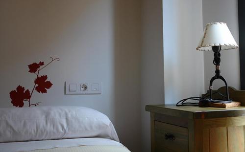 a lamp sitting on a table next to a bed at Apartamentos Laurel in Logroño