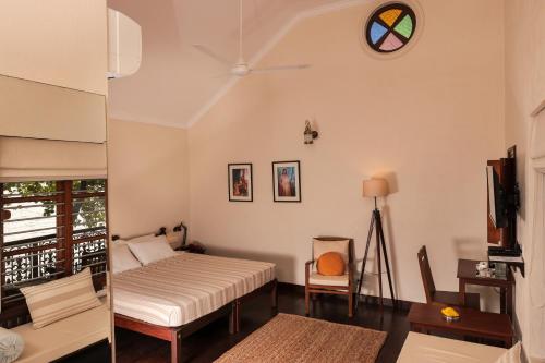 a bedroom with two beds and a clock on the wall at Samiira on Ashtamudi Lake in Kollam