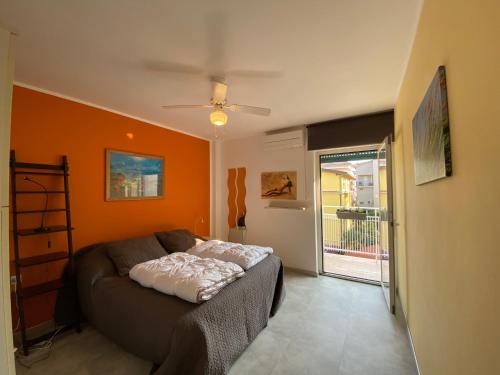 a living room with a couch with an orange wall at Anfora MitoMare in Grado