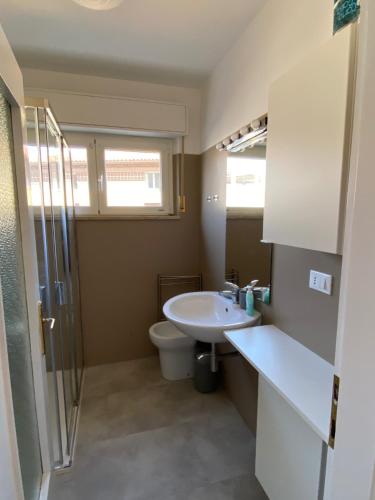 a bathroom with a sink and a toilet at Anfora MitoMare in Grado