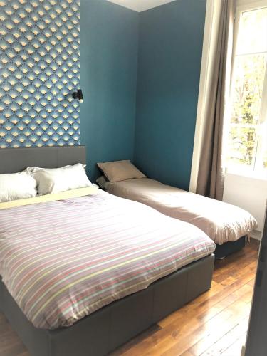 - 2 lits dans une chambre avec des murs bleus et une fenêtre dans l'établissement Côté Cour Lyon Part Dieu, à Lyon