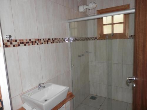 a bathroom with a sink and a shower at Chalé Rio das Pedras in Santo Antônio do Pinhal