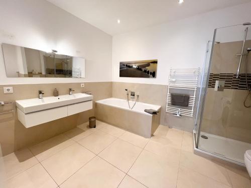 a bathroom with a tub and a sink and a shower at Centerapartments Premium DeLuxe in Düsseldorf