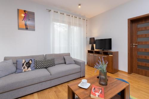 a living room with a couch and a tv at Villa 4 Pory Roku by Renters in Jastrzębia Góra