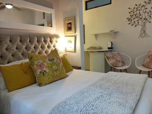 a bedroom with a large white bed with yellow pillows at Royal Palm Suite, Villa Roc Guesthouse, Salt Rock Ballito, Solar Power in Salt Rock