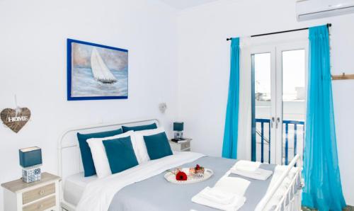Mykonos Panorama with Private Terrace & Sea View في مدينة ميكونوس: غرفة نوم بها سرير عليه صينية طعام