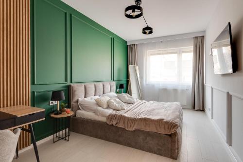 1 dormitorio con paredes verdes y 1 cama con almohadas en Magic Place - Francuska Park en Katowice