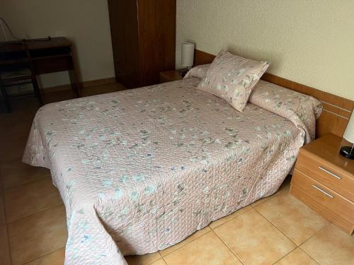 a bedroom with a bed with a pink comforter at LA CASONA DE PALMIRA in Caín