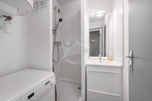 een witte badkamer met een wastafel en een douche bij AS21388 - P2 avec vue dégagée et arborée avec parking privé in Le Grau-du-Roi