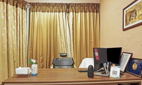 ein Hotelzimmer mit einem Schreibtisch und einem Computer darauf in der Unterkunft Treebo Trend Excellent Home in Pune