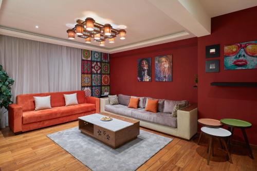 a living room with red walls and orange furniture at Golden Park Hotel Cairo, Heliopolis in Cairo
