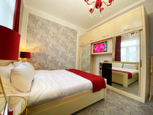 um quarto com uma cama e uma televisão em Hotel Orange Kutaisi em Kutaisi