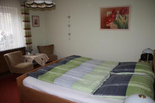 Una cama con una manta verde y azul. en Gästewohnung Kurz, en Sankt Goar