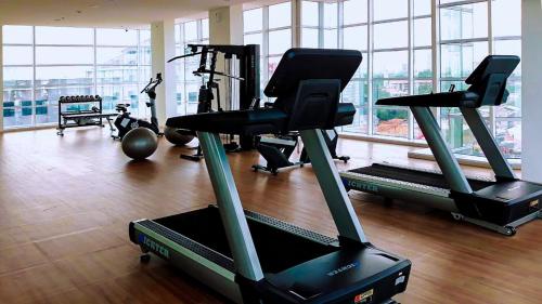a gym with treadmills and exercise bikes in a room at Ventura Room at TreePark City in Kebun Nanas