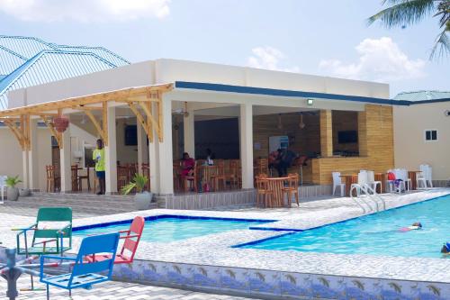 a swimming pool with chairs and a house at Chibuba Airport Accommodation in Dar es Salaam