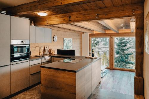 a kitchen with wooden ceilings and a large window at Planai Apartment mit Dachstein Blick in Schladming