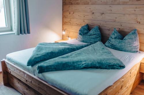 a bed with blue sheets and pillows on it at Planai Apartment mit Dachstein Blick in Schladming