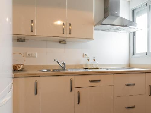 una cocina con armarios blancos y fregadero en Apartamento céntrico Loyola, en Córdoba