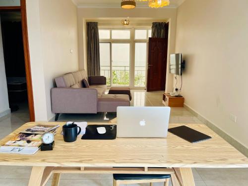 a living room with a table with a laptop on it at Cozy Private Apartments with beautiful view of Lake Victoria in Mwanza